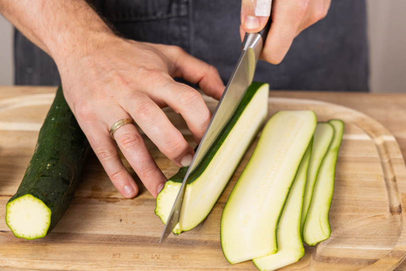 Zucchini in längliche Streifen schneiden