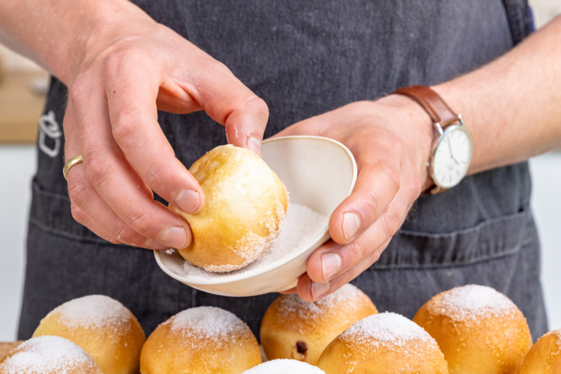 Berliner aus der Heißluftfritteuse in Zucker tunken