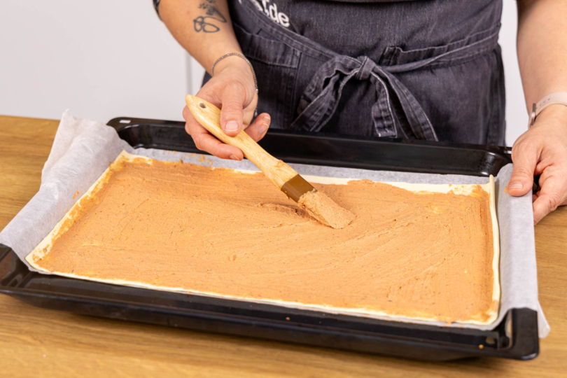 Teig mit Frischkäsecreme bestreichen