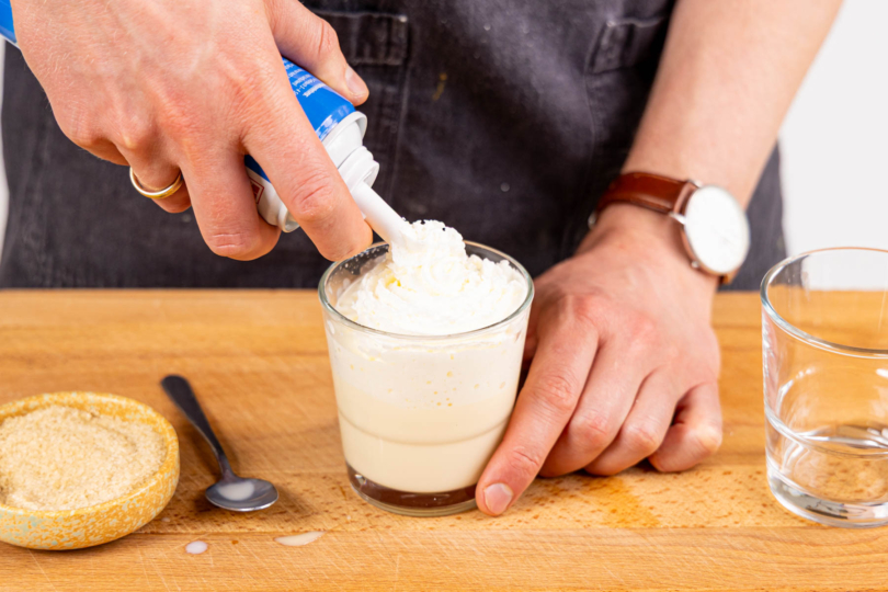 Bombardino mit Sahne garnieren