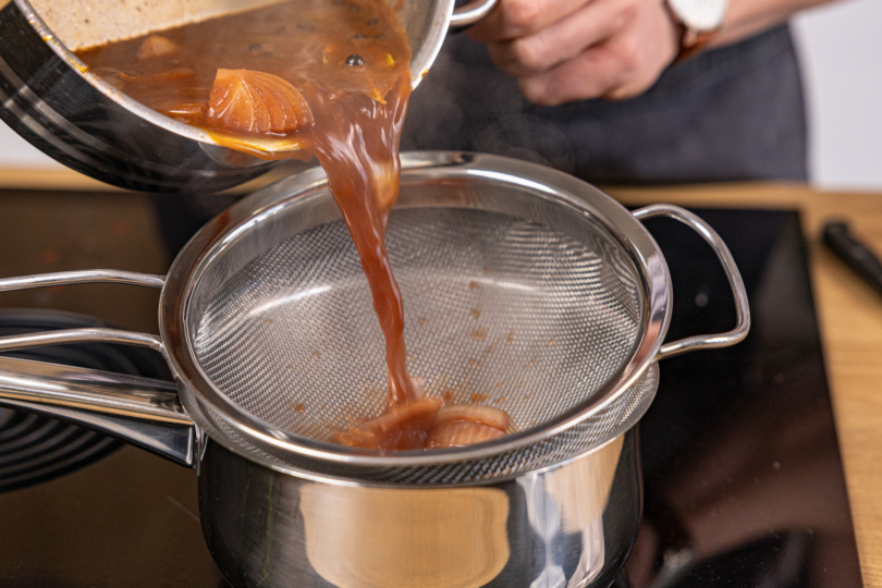 braune Soße durch ein Sieb geben