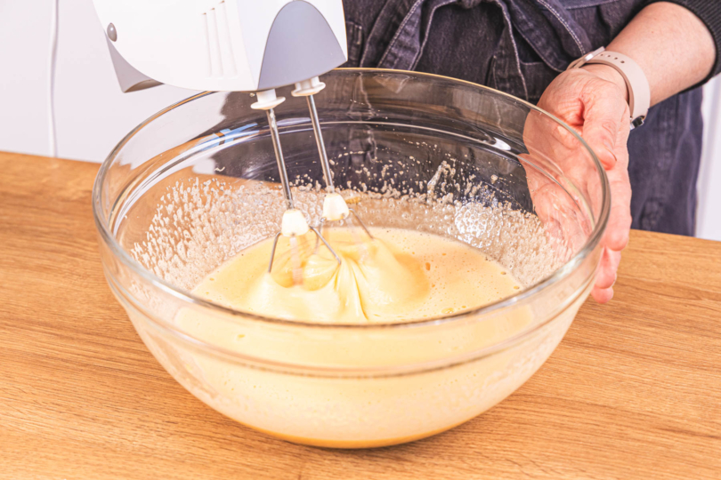 Zucker und Eier mit Handrührgerät verrühren