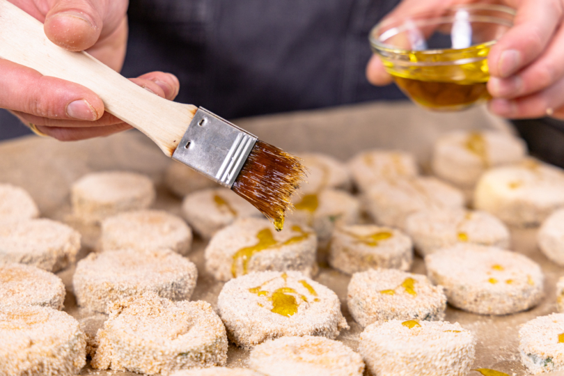 panierte Zucchinischeiben mit Öl bestreichen