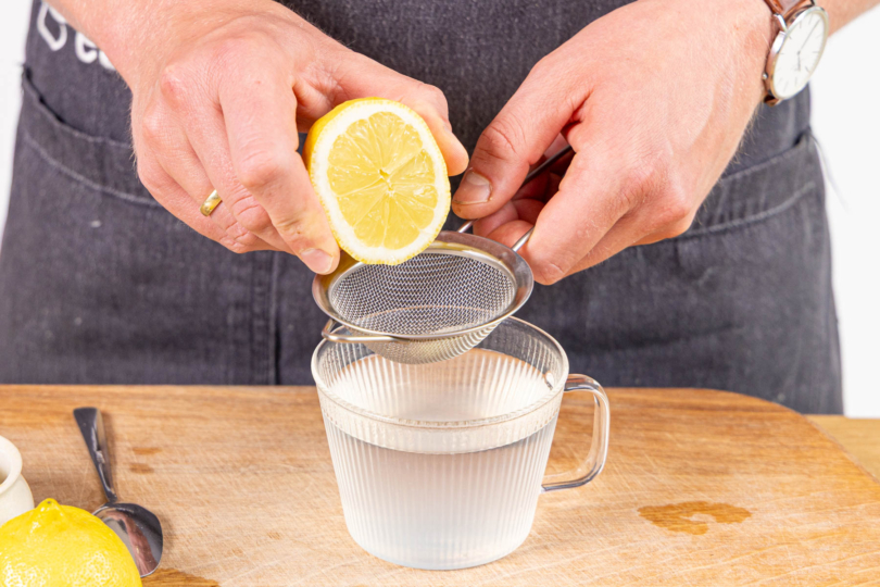 Zitronensaft ins Wasser pressen