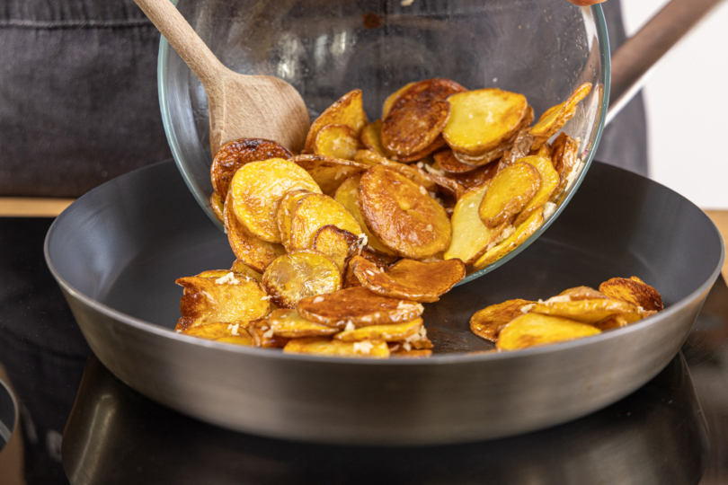 Kartoffeln mit Knoblauch in der Pfanne erwärmen