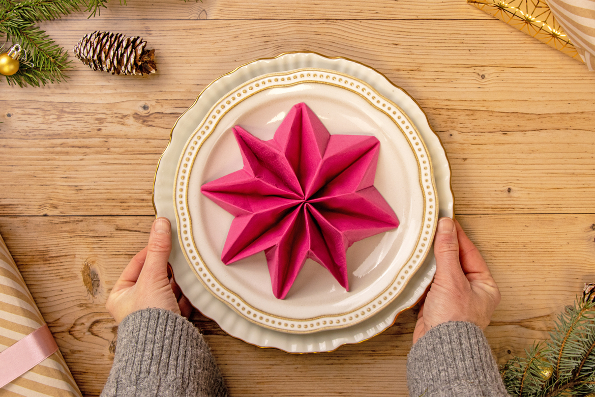 Stern aus Serviette auf Teller platzieren