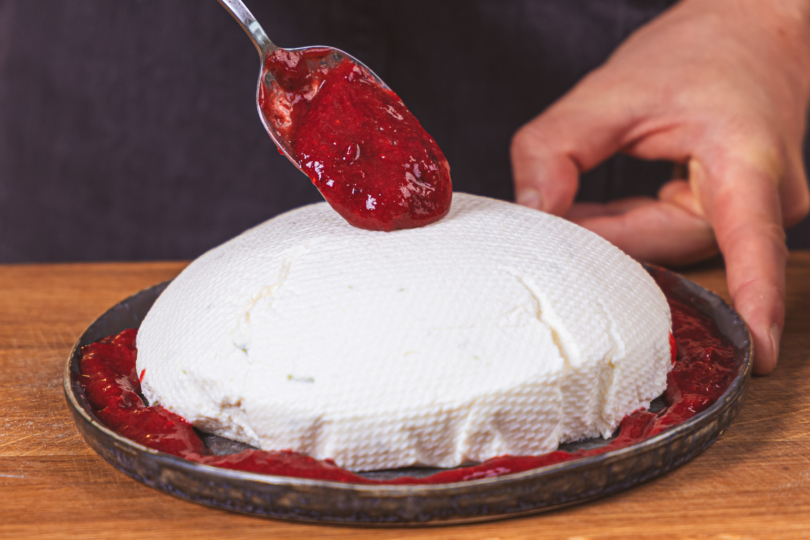 Vegane Joghurtbombe mit Beeren-Sauce garnieren