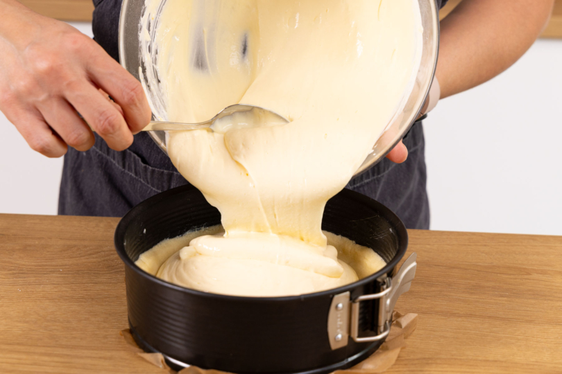 Cheesecakemasse zu Teig geben.