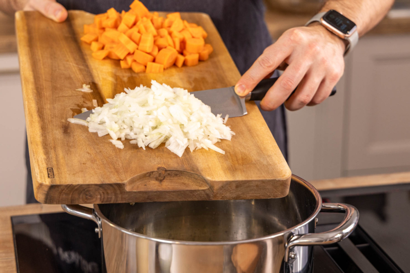 Karotten und Zwiebel in Topf geben