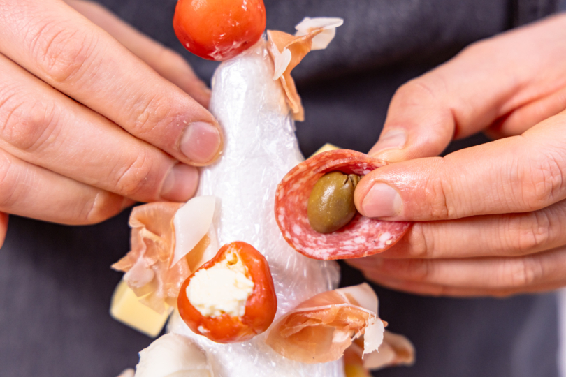 Salami mit Olive befestigen