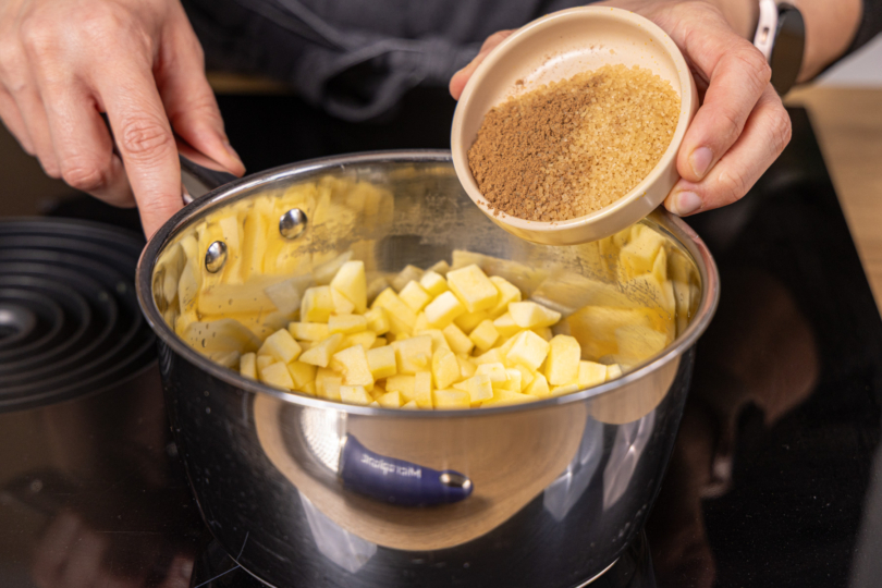 Zucker zu den Äpfeln geben