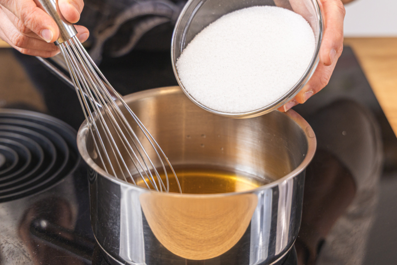 Zucker in den Topf geben