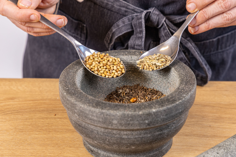 Gewürze in den Mörser geben