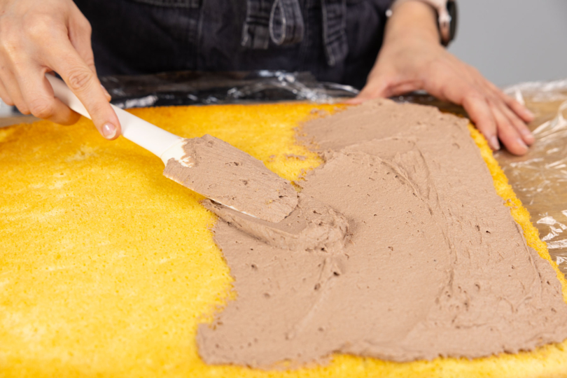 Schokocreme auf dem Biskuitteig verstreichen.