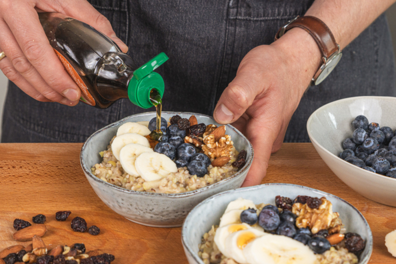 Buchweizen-Porridge mit Beeren und Ahornsirup garnieren
