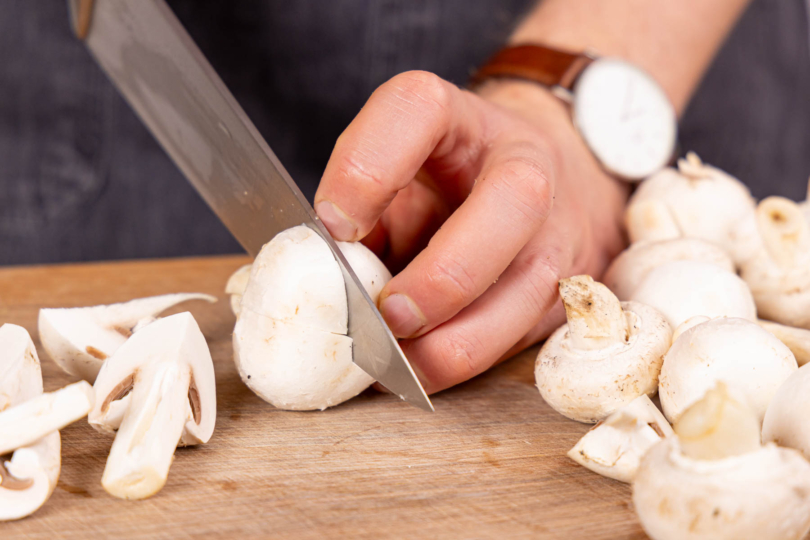 Champignons putzen und je nach Größe halbieren