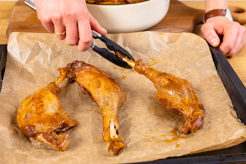 geschmorte Gänsekeulen auf Backblech geben
