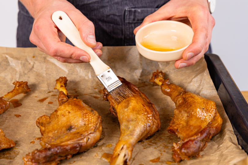 geschmorte Gänsekeulen mit Honig einstreichen