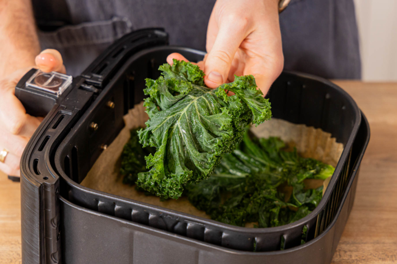 gewaschenen, trockenen Grünkohl in den Fritteusenkorb legen
