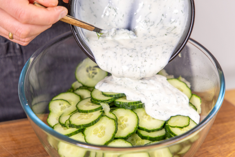 Dressing zu den Gurken geben