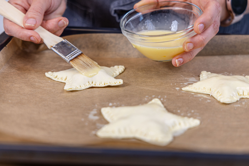 Herzhafte Blätterteigsterne mit Ei bepinseln