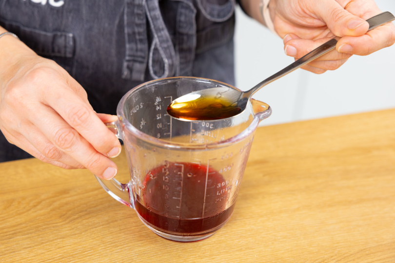 Amaretto in den Kirschsaft geben.
