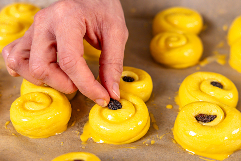 Lussekatter mit Rosinen dekorieren