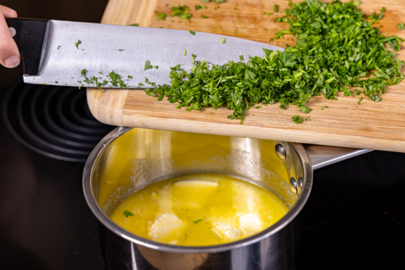 Kräuter zur Butter geben