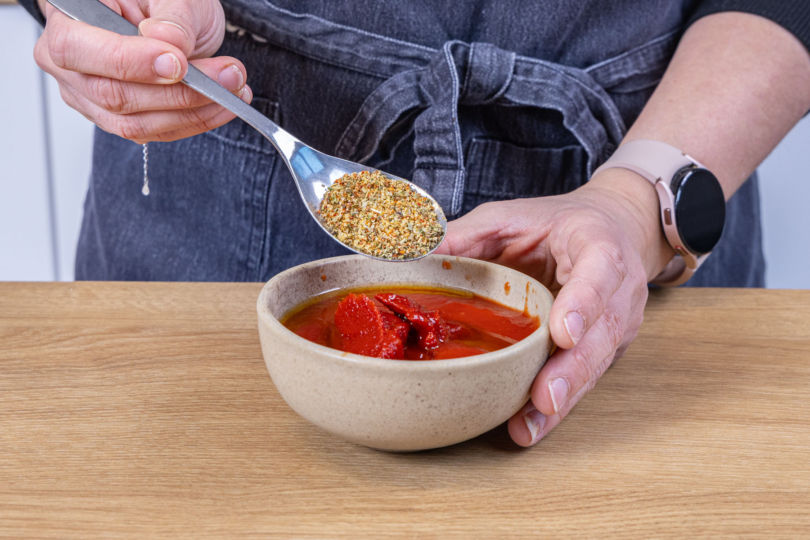 Kräuter zum Tomatenmark geben