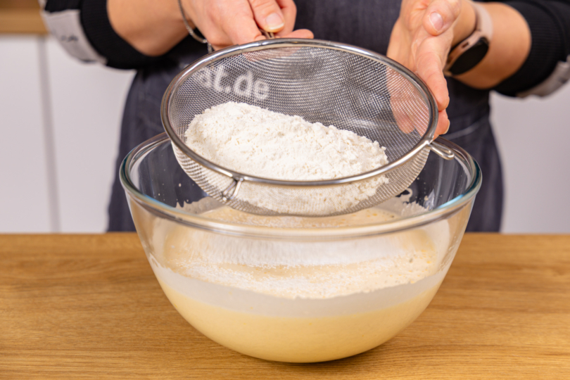trockene Zutaten zum Biskuitteig sieben
