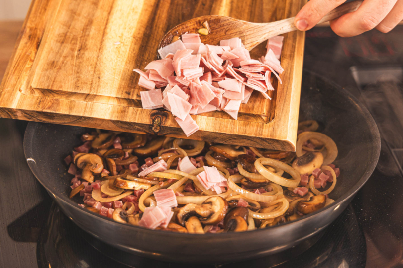 Kochschinken zur Zwiebelmasse geben.