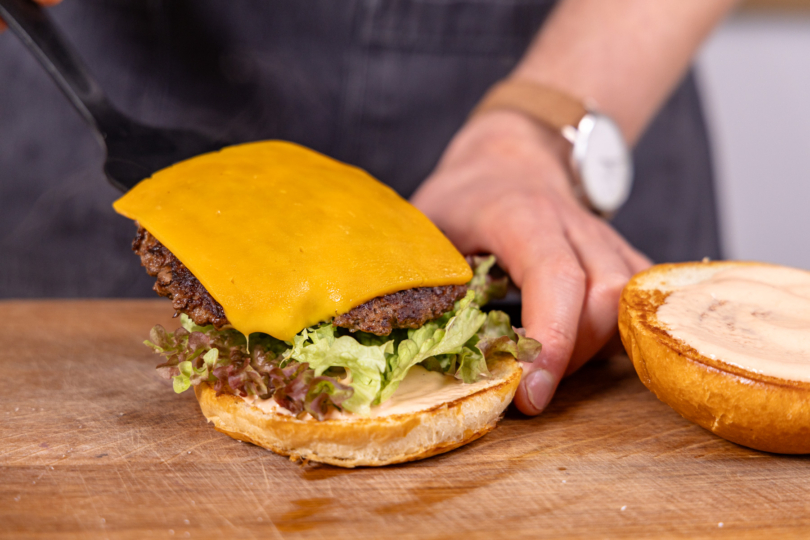Smash Burger-Patty auf Salat legen