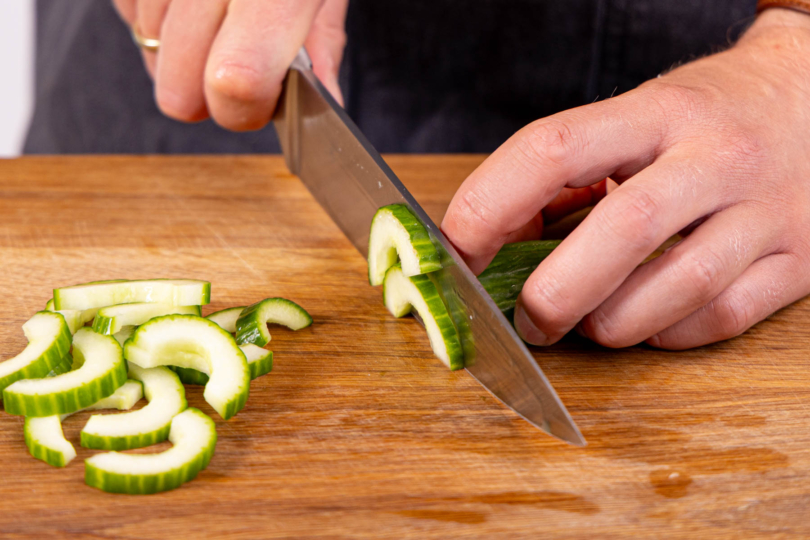 Gurke halbieren und in Halbmonde schneiden