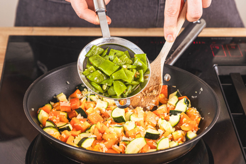 Bohnen zum Gemüse in die Pfanne geben