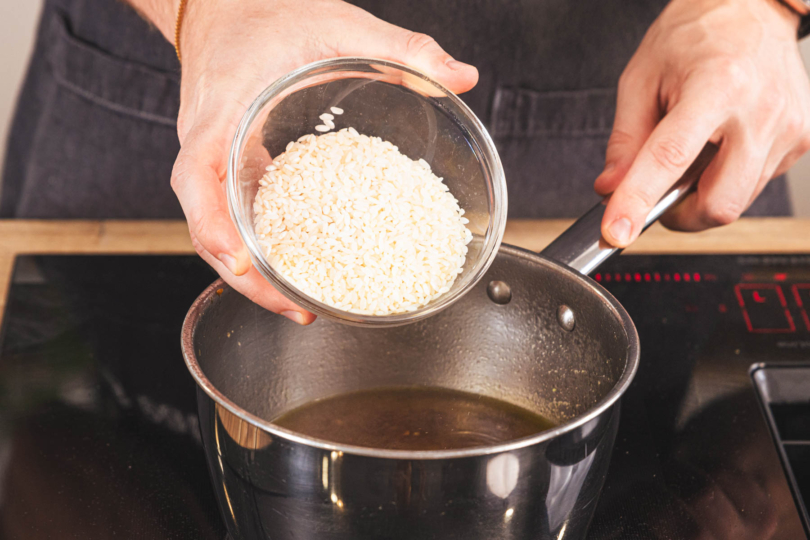 Reis in die Brühe geben