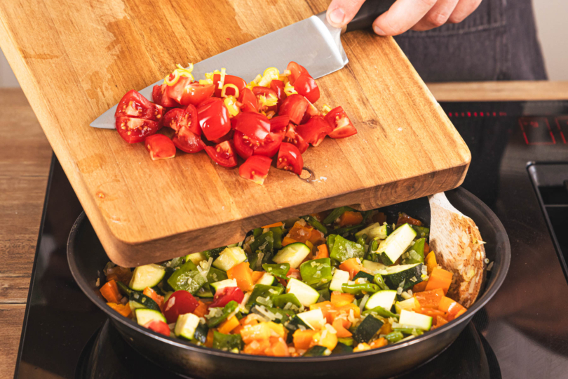 Tomaten zur Paella geben