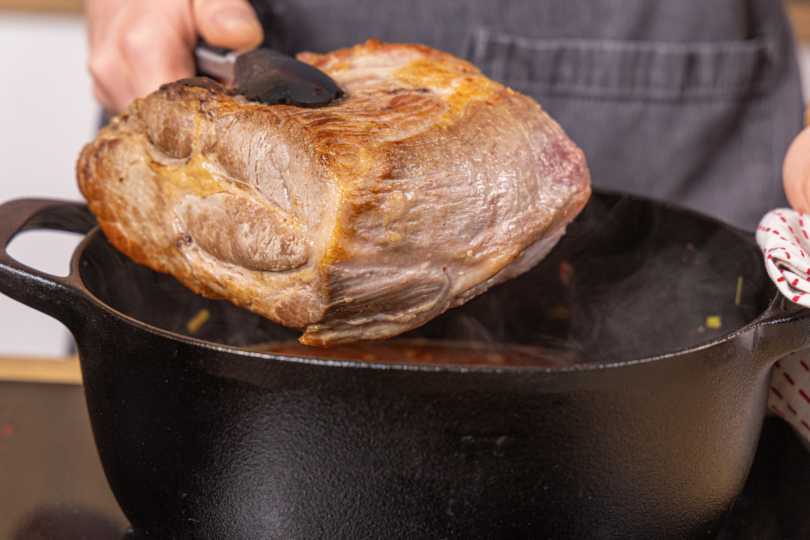 Schweinebraten in den Bräter geben