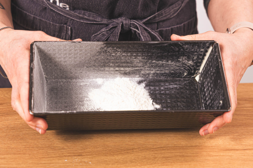 eingefettete Kastenform mit Mehl bestäuben