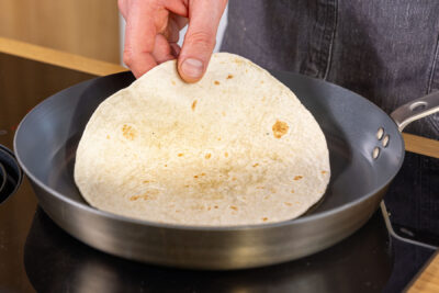 Tortillas für Burrata Tacos in Pfanne erwärmen
