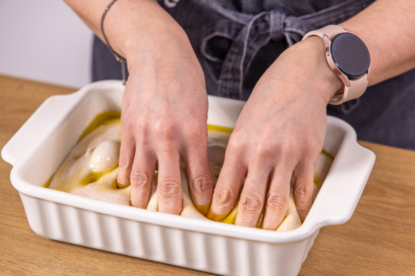 Mit den Fingern Dellen in den Teig drücken