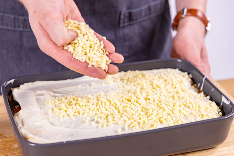 Grünkohl Lasagne mit Käse bestreuen