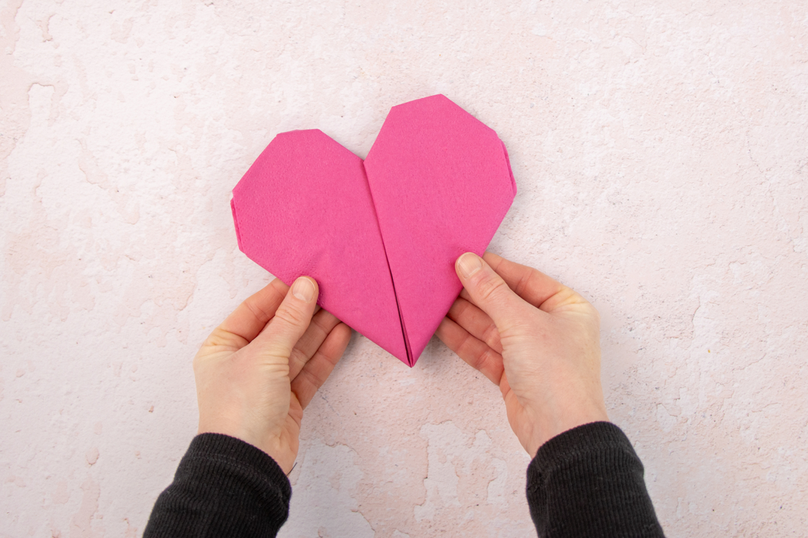 Servietten Herz in den Händen haltend