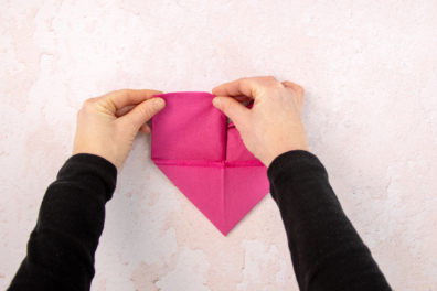 Obere Ecken der Stoffserviette schräg nach unten falten