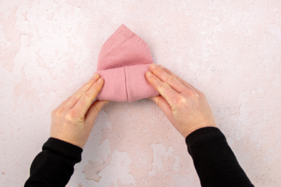 Stoffserviette mit den Händen aufrollen