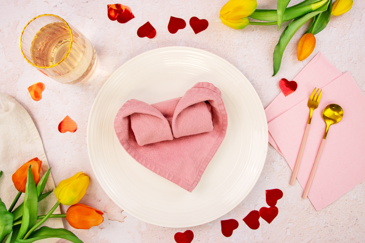 Gefaltetes Herz aus Stoffserviette als Tischdeko zum Valentinstag