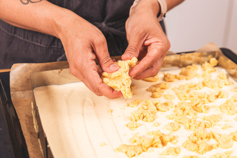 Streusel auf dem Käsekuchen verteilen