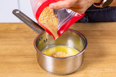 Keksbrösel zur geschmolzenen Butter geben