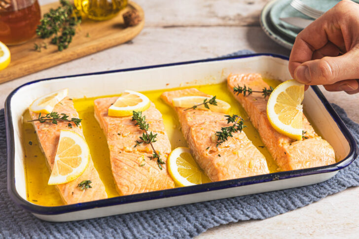 Zitronenscheiben auf den Lachs aus dem Ofen legen 