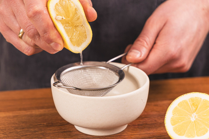 Zitrone in eine Schüssel auspressen