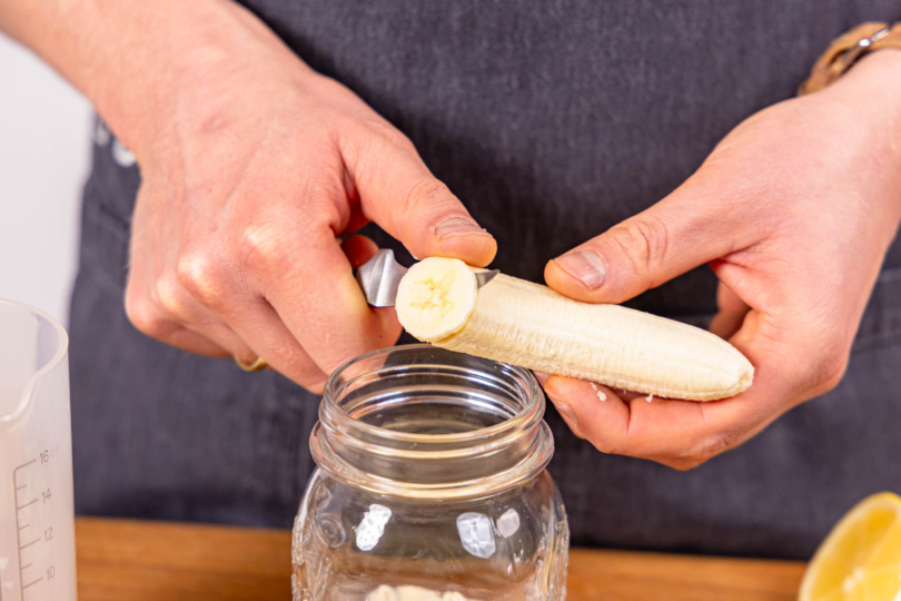 halbe Banane in Scheiben ins Glas schneiden